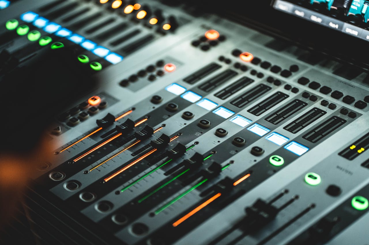 Close-up of a professional audio mixing console with illuminated LED indicators in a music studio.